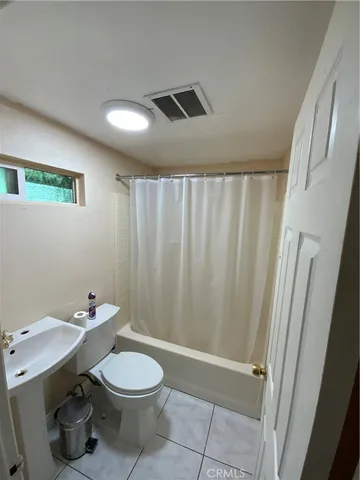 a bathroom with a sink a toilet and shower curtain