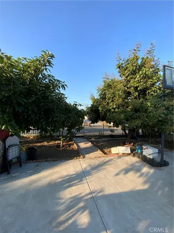 a view of swimming pool with outdoor seating and trees in the background