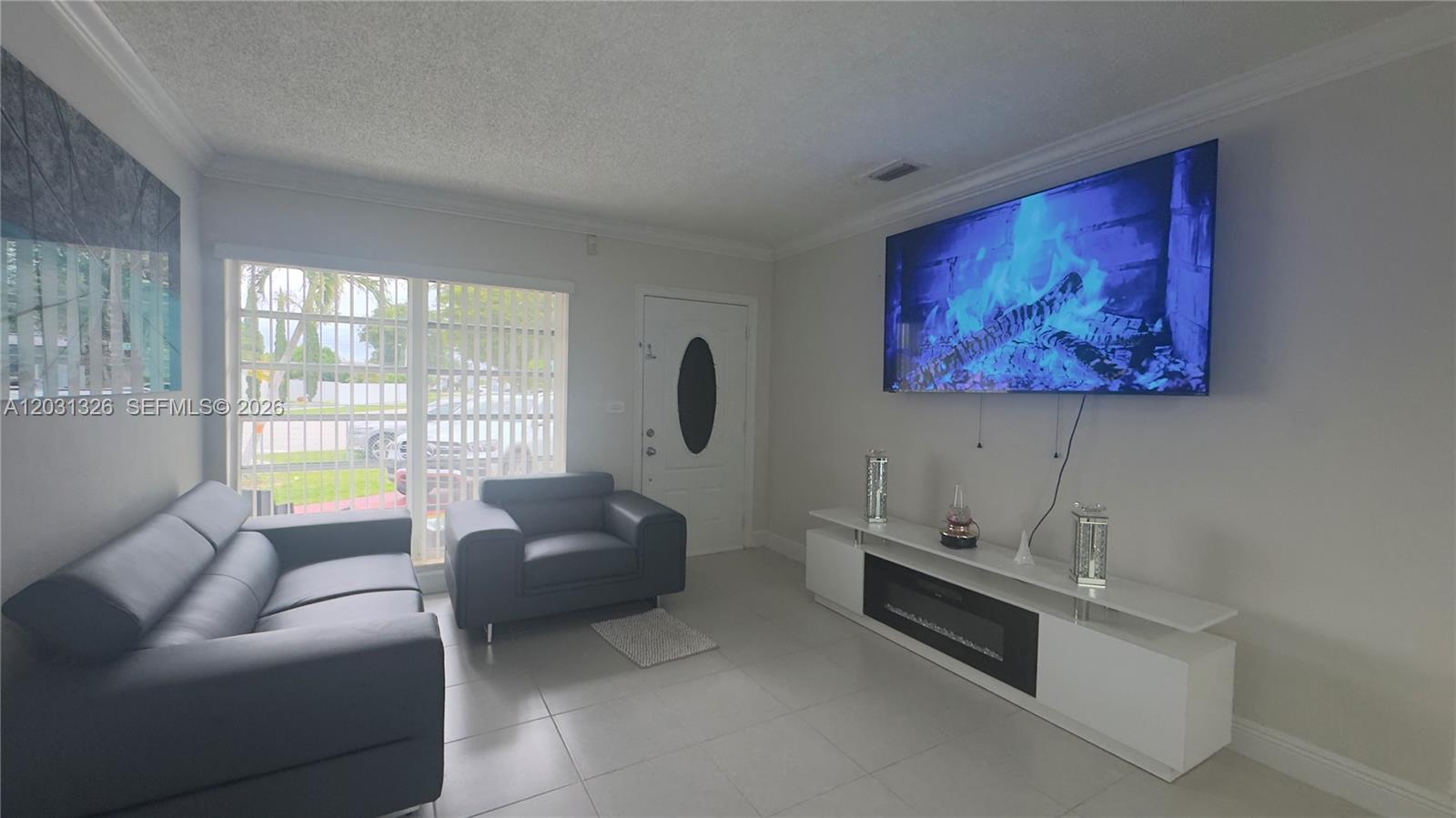 12480 Southwest 189th Street Miami, FL 33177 - Photo 2 of 25 a living room with furniture a window and a flat screen tv
