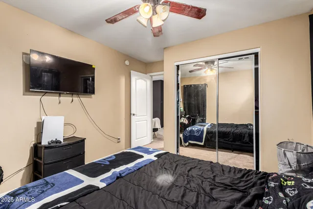 a bedroom with a bed and a flat tv screen on the dresser