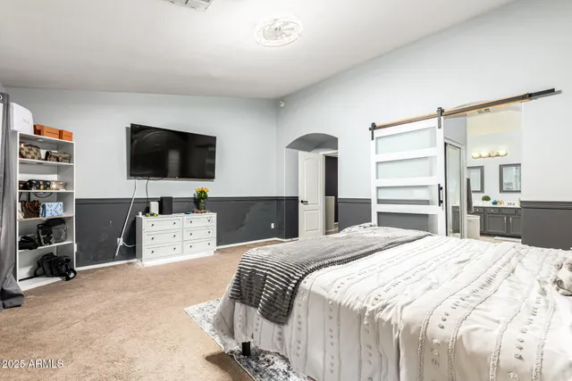 a bedroom with a bed and a flat screen television