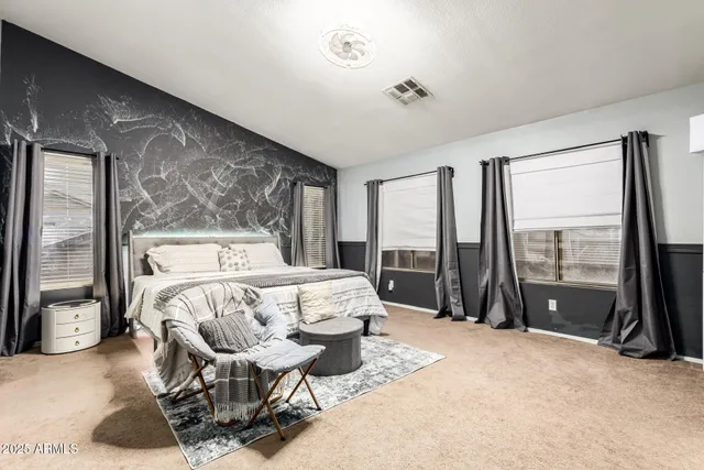 a bedroom with a bed and a large window