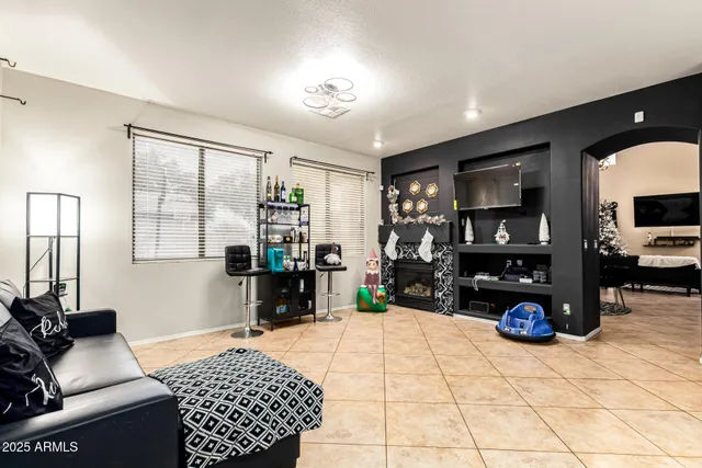 a bedroom with furniture a flat screen tv and a large window