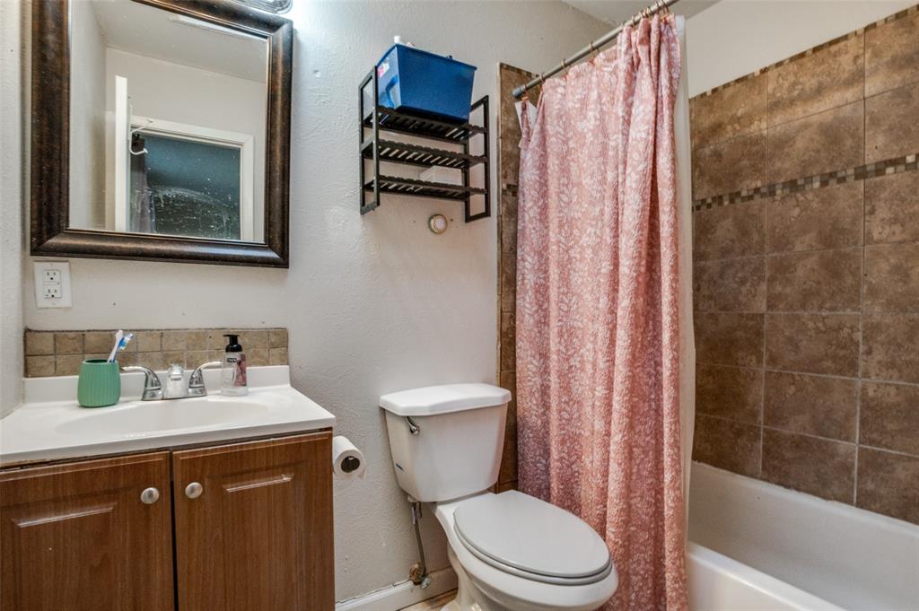 6102 Kelly Elliott Road Arlington, TX 76001 - Photo 11 of 12 a bathroom with a toilet a sink and a mirror