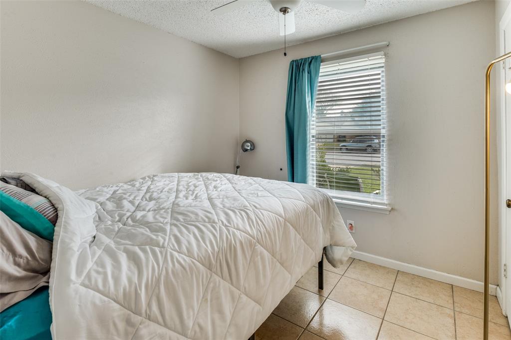 6102 Kelly Elliott Road Arlington, TX 76001 - Photo 6 of 12 a bed sitting in a bedroom next to a window