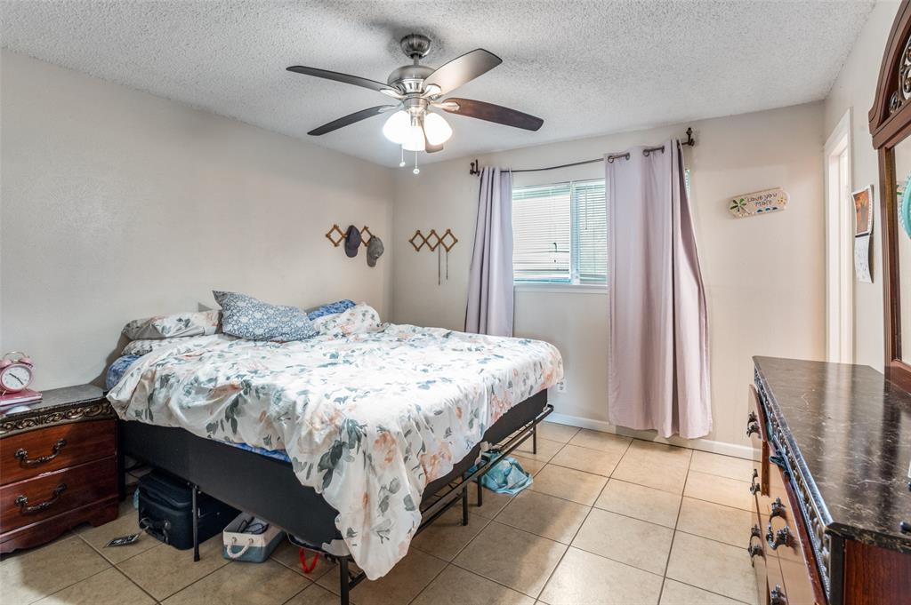 6102 Kelly Elliott Road Arlington, TX 76001 - Photo 9 of 12 a bedroom with a bed and a chandelier