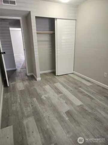 an empty room with wooden floor and closet