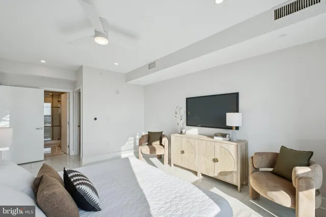 a living room with stainless steel appliances furniture and a kitchen view