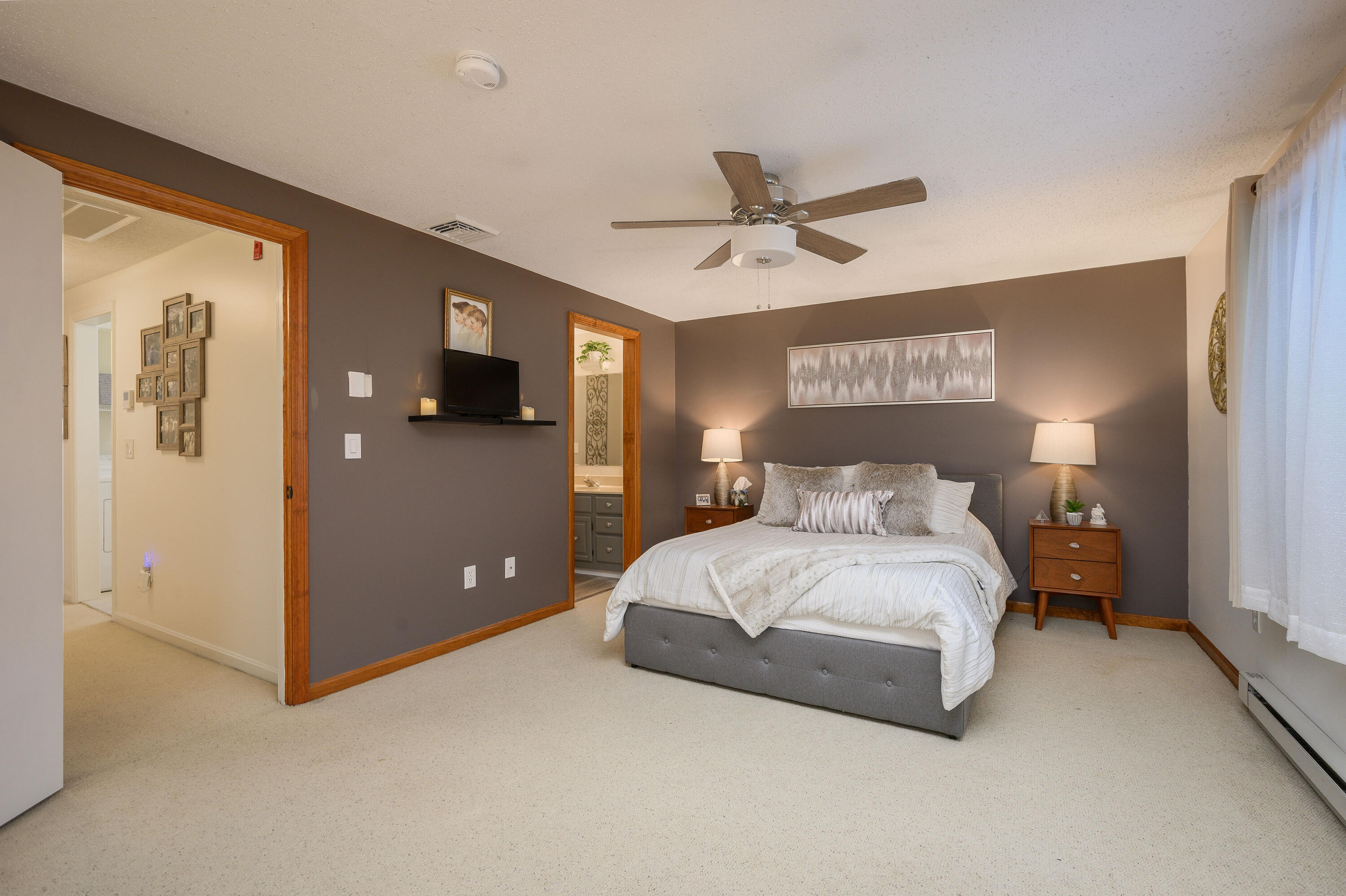 174 Lowell Road, Unit D39 Mashpee, MA 02649 - Photo 18 of 32 a bedroom with a bed and a chandelier