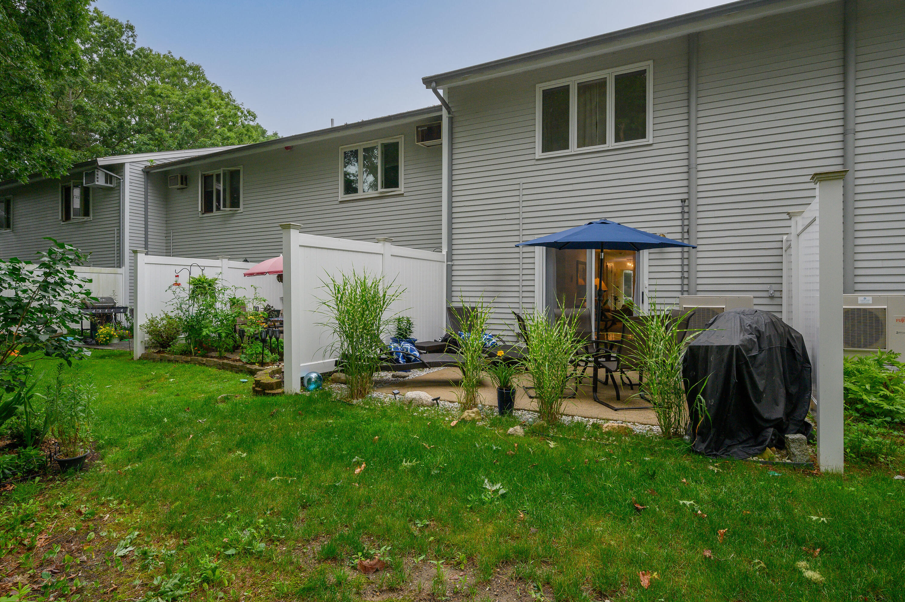 174 Lowell Road, Unit D39 Mashpee, MA 02649 - Photo 30 of 32 a view of a house with a yard and plants