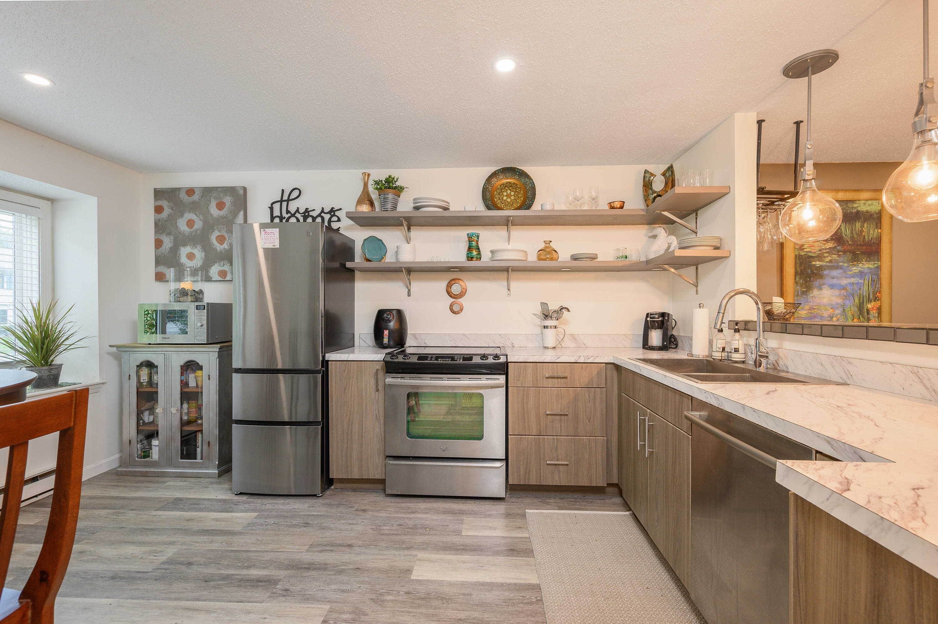 174 Lowell Road, Unit D39 Mashpee, MA 02649 - Photo 10 of 32 a kitchen with stainless steel appliances granite countertop a refrigerator a sink dishwasher a stove with wooden floor