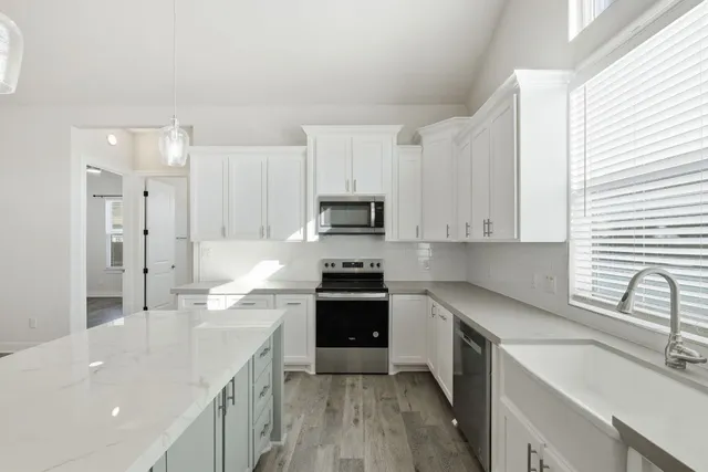 a kitchen with stainless steel appliances granite countertop a sink stove and refrigerator