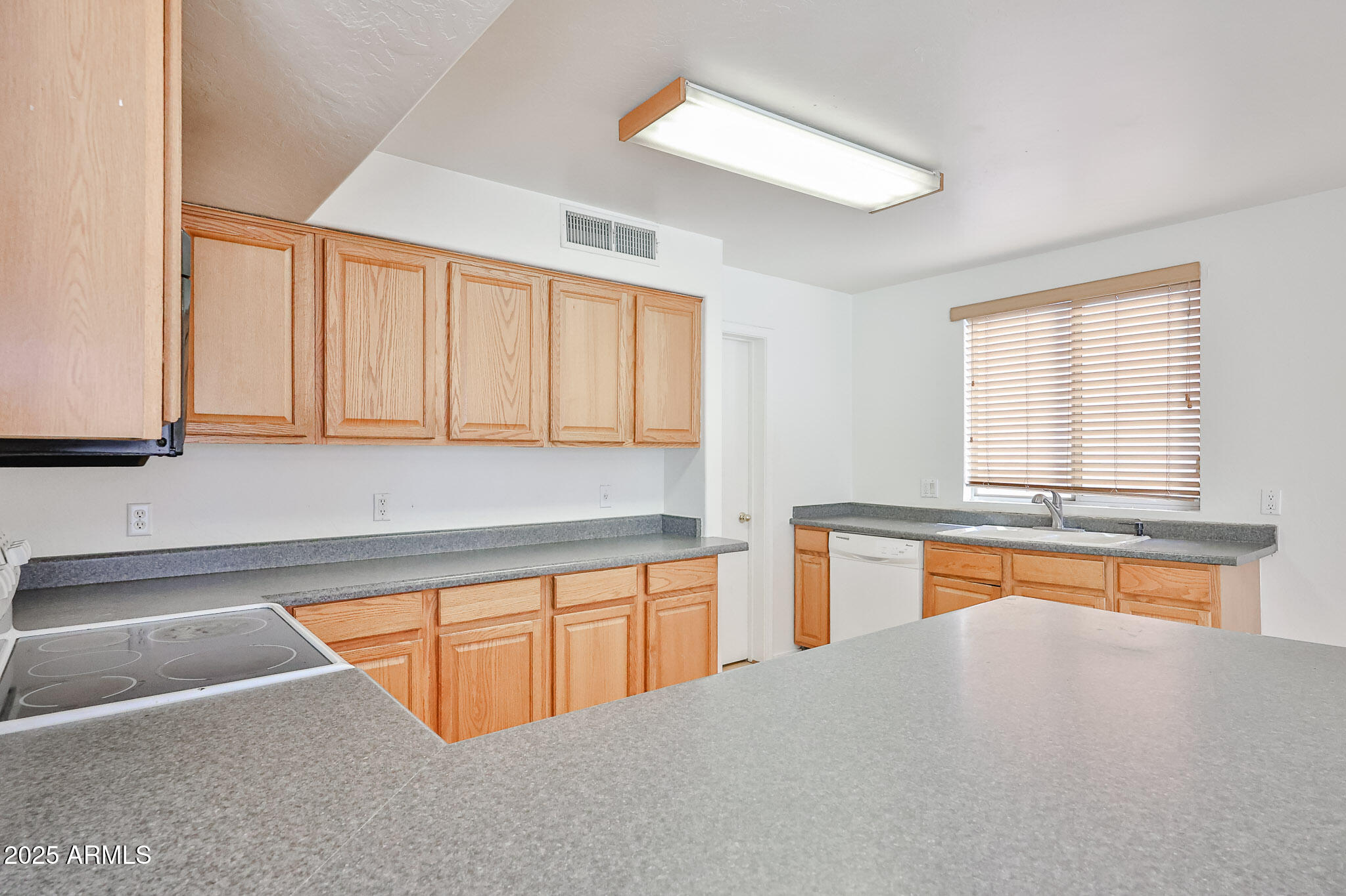 7681 West Lamar Road Glendale, AZ 85303 - Photo 16 of 36 a kitchen with stainless steel appliances granite countertop a stove a sink and a microwave