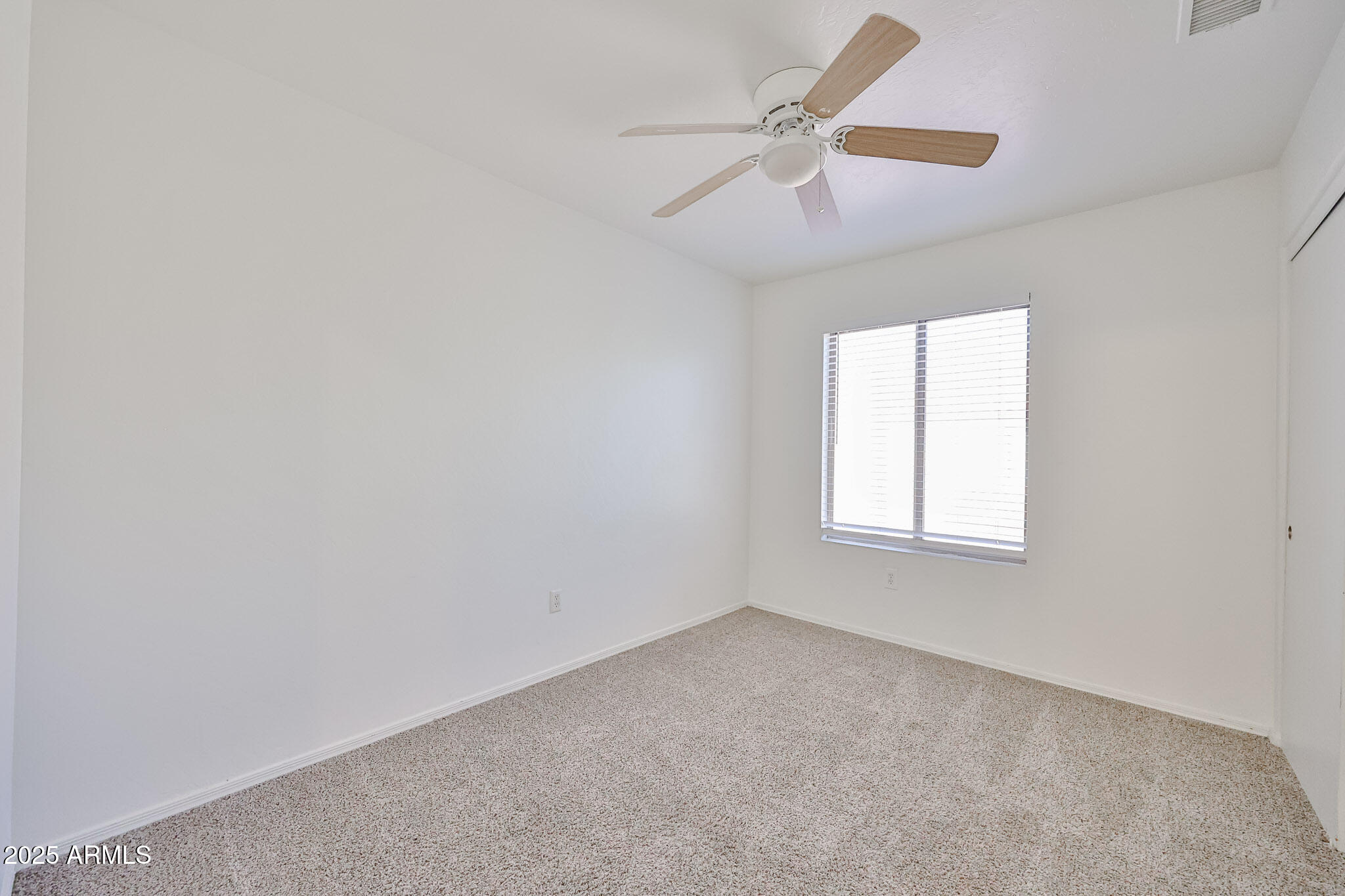 7681 West Lamar Road Glendale, AZ 85303 - Photo 24 of 36 an empty room with a window and a fan