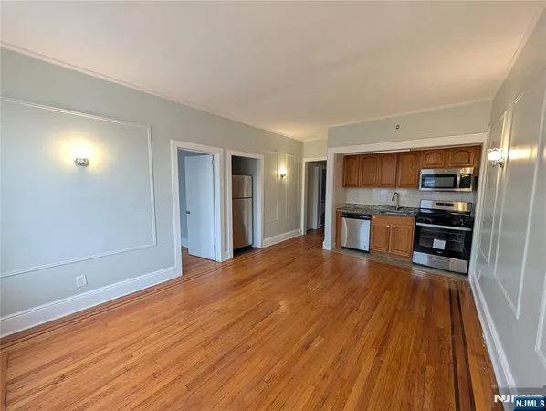 a view of kitchen with refrigerator stove microwave and wooden floor