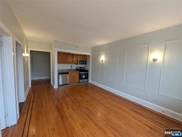 a view of empty room with wooden floor