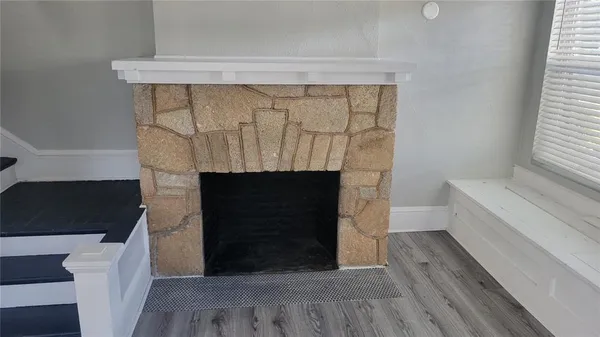 a room with a fireplace and a wooden floor