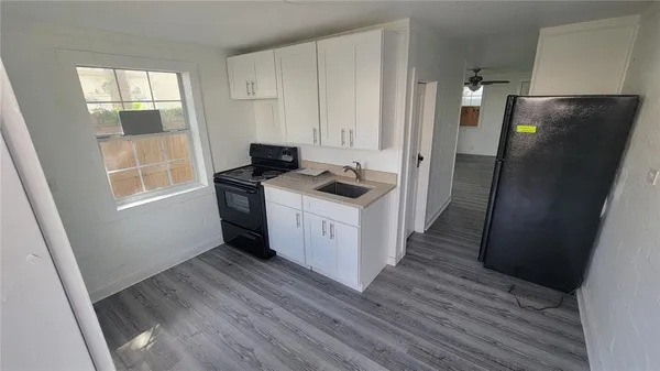 a kitchen with stainless steel appliances a refrigerator and wooden floor