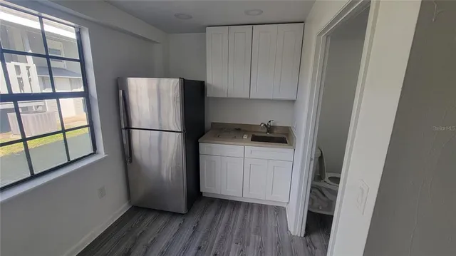 a kitchen with a refrigerator and a stove top oven