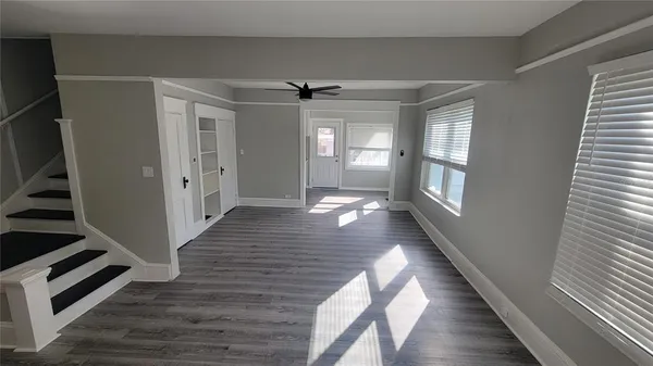 a view of a hallway with wooden floor and staircase