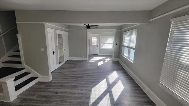 a view of a hallway with wooden floor and staircase