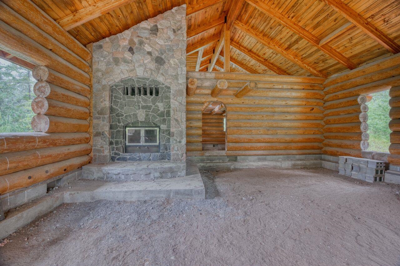 2003 Brimson Road Brimson, MN 55602 - Photo 3 of 25 Unfurnished living room with wooden ceiling, a stone fireplace, high vaulted ceiling, rustic walls, and carpet