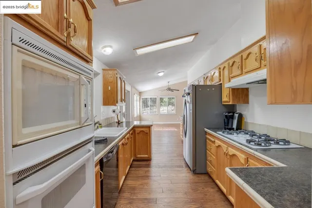 a kitchen with stainless steel appliances granite countertop a stove a sink and a refrigerator