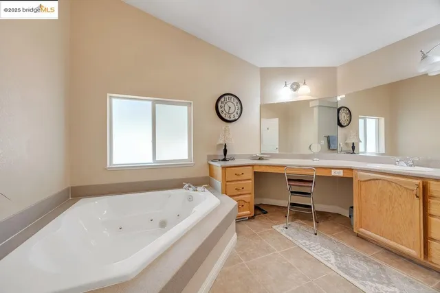a bathroom with a tub a sink and a large mirror