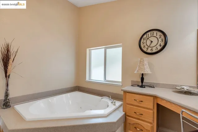 a bathroom with a tub sink and a mirror