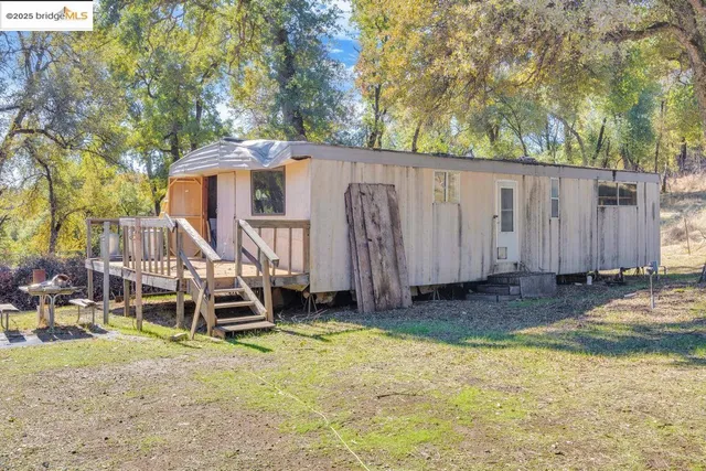 a wooden house with trees in the background