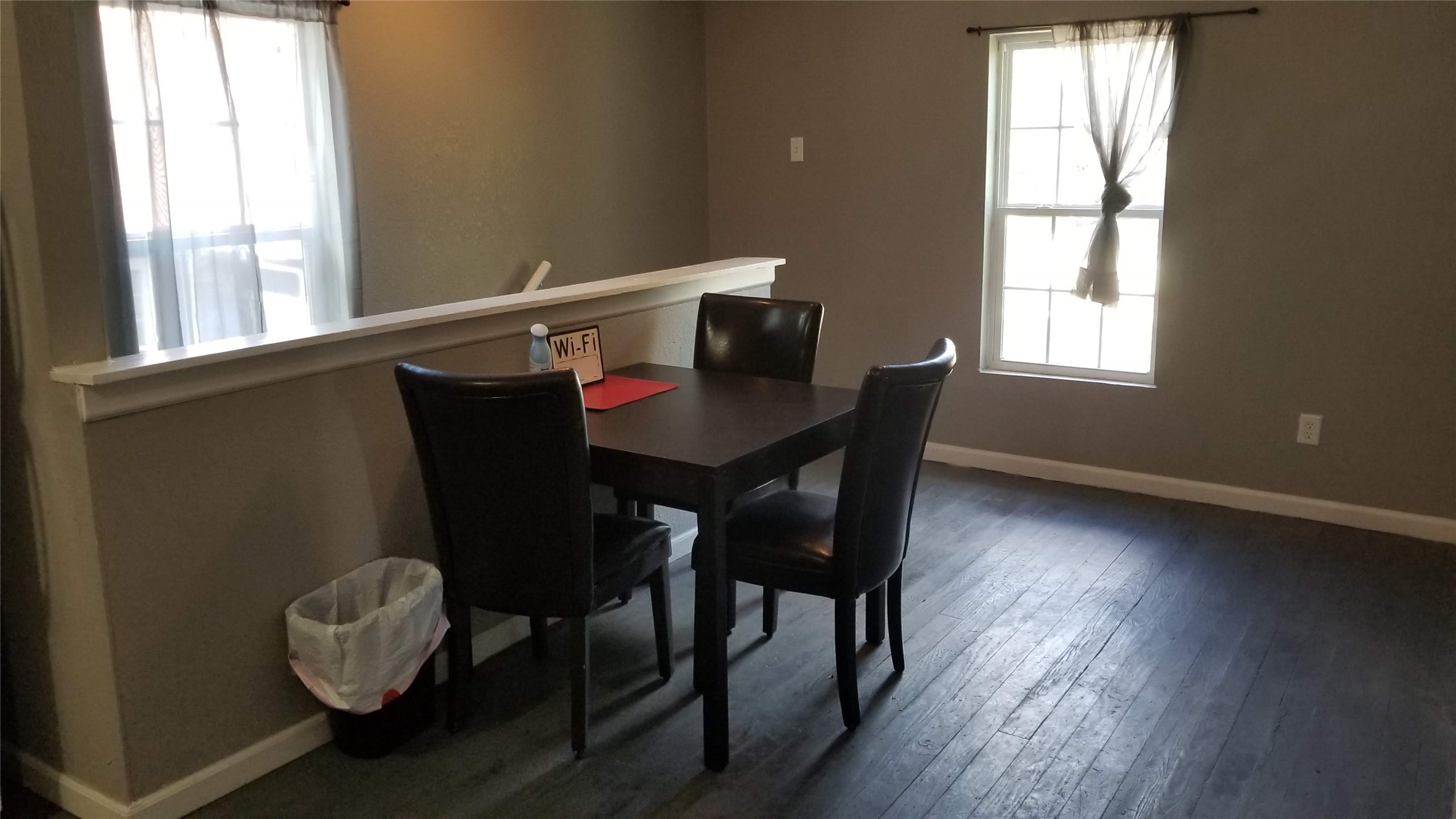 409 South Main Street Taylor, TX 76574 - Photo 8 of 9 Dining area with dark wood flooring and ample natural light from two windows.