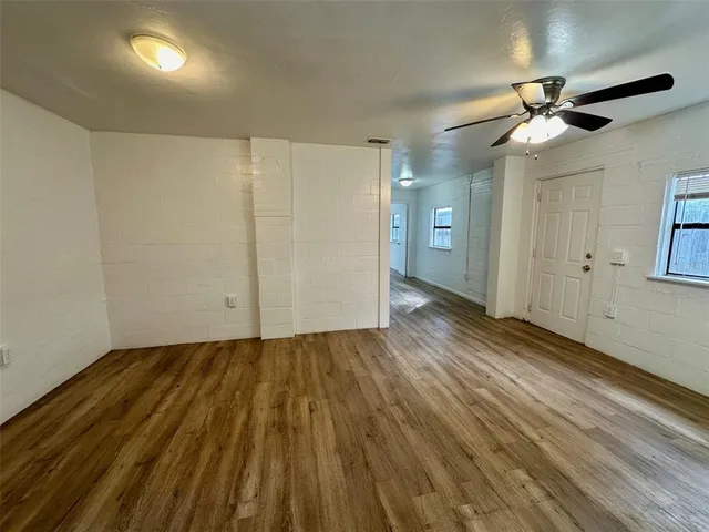 an empty room with wooden floor and window