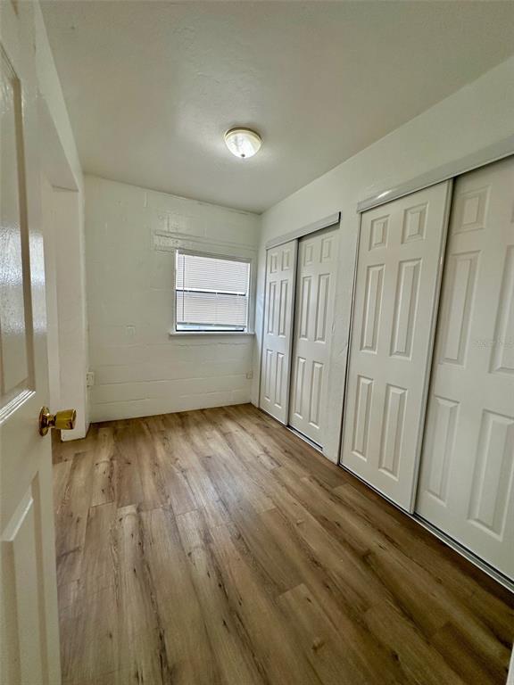 647 Northeast Waldo Road Gainesville, FL 32641 - Photo 6 of 25 an empty room with wooden floor and window