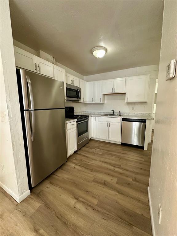 647 Northeast Waldo Road Gainesville, FL 32641 - Photo 9 of 25 a kitchen with stainless steel appliances granite countertop a refrigerator a stove a sink and a microwave