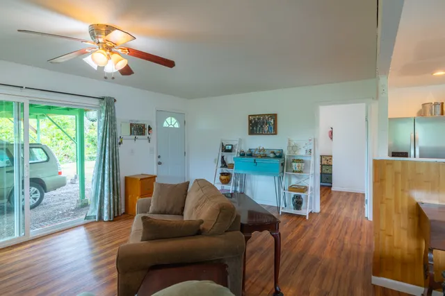 a kitchen with stainless steel appliances a sink a stove a refrigerator white cabinets and wooden floor