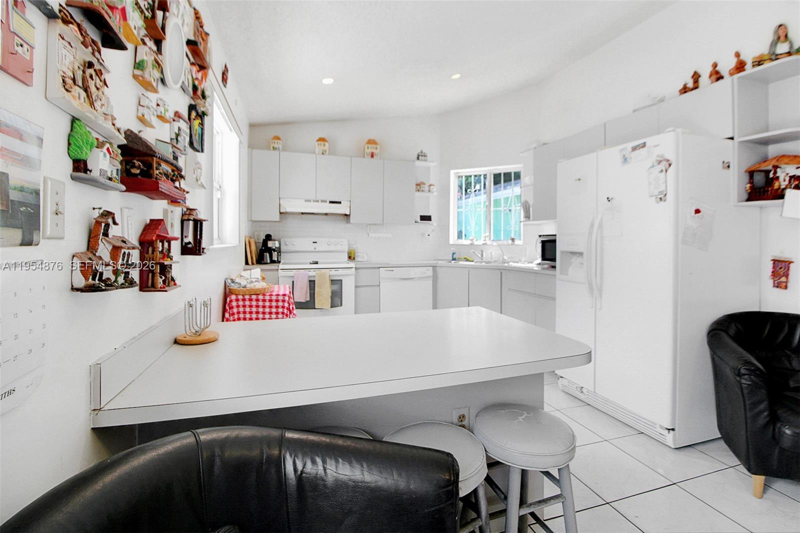 11942 Southwest 210th Street Miami, FL 33177 - Photo 11 of 19 a white kitchen with a sink a stove and a refrigerator