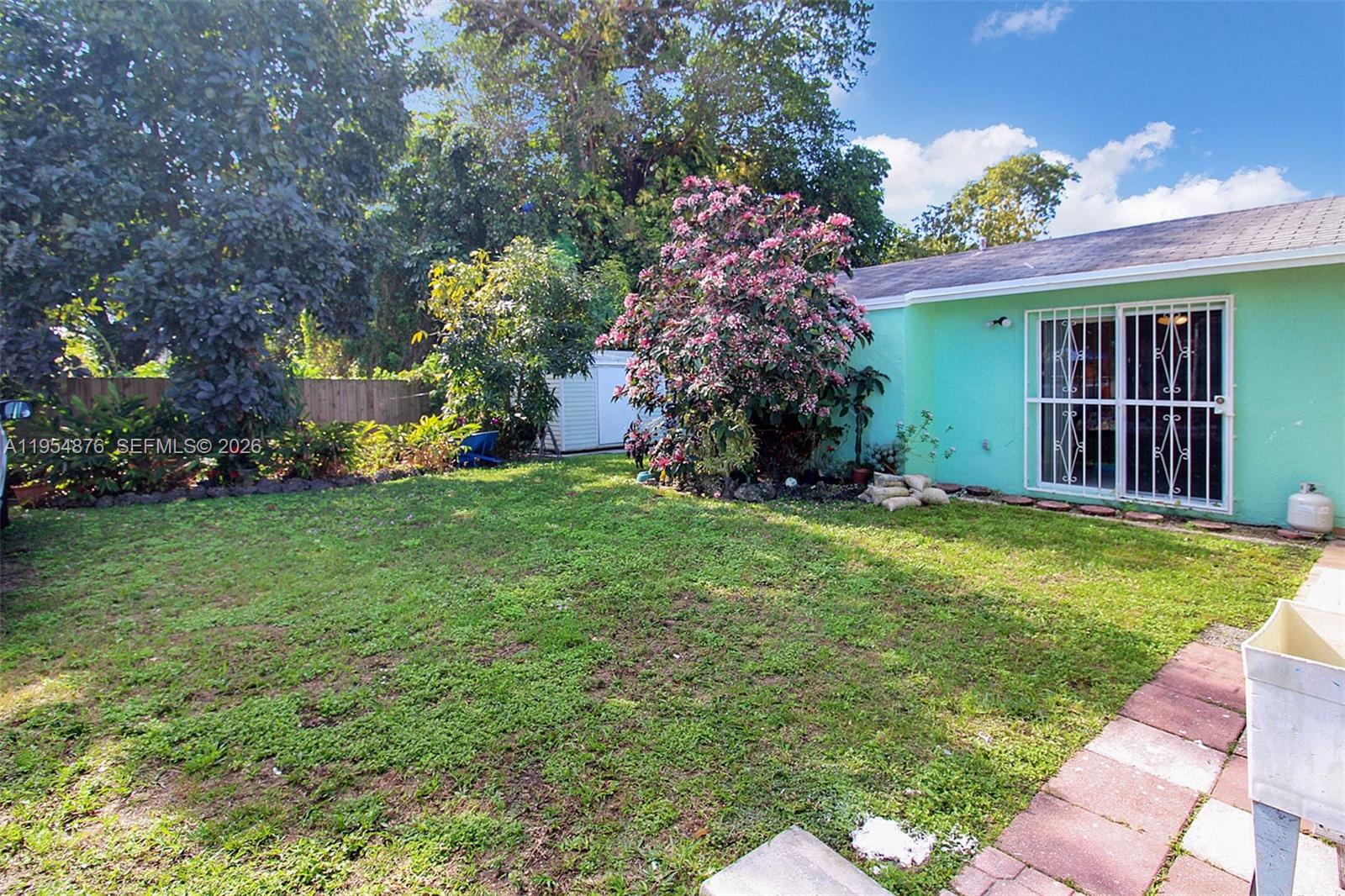 11942 Southwest 210th Street Miami, FL 33177 - Photo 4 of 19 a view of a house with a yard and potted plants
