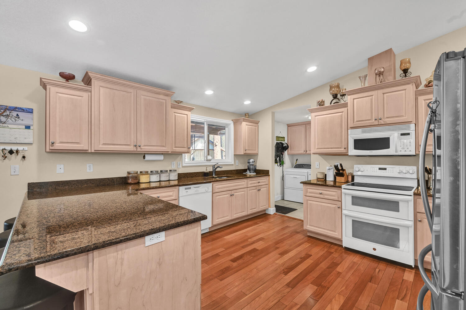 14840 Laurel Road La Pine, OR 97739 - Photo 7 of 32 a kitchen with stainless steel appliances granite countertop a stove a sink and white cabinets