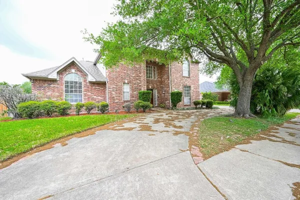 a front view of a house with a yard and trees