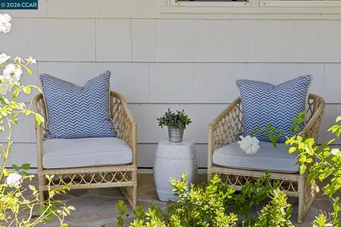 a view of a patio with table and chairs potted plants and large tree