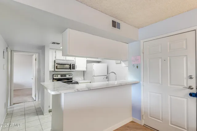 a kitchen with kitchen island a sink a counter space and stainless steel appliances