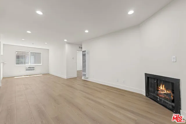 an empty room with wooden floor and fireplace