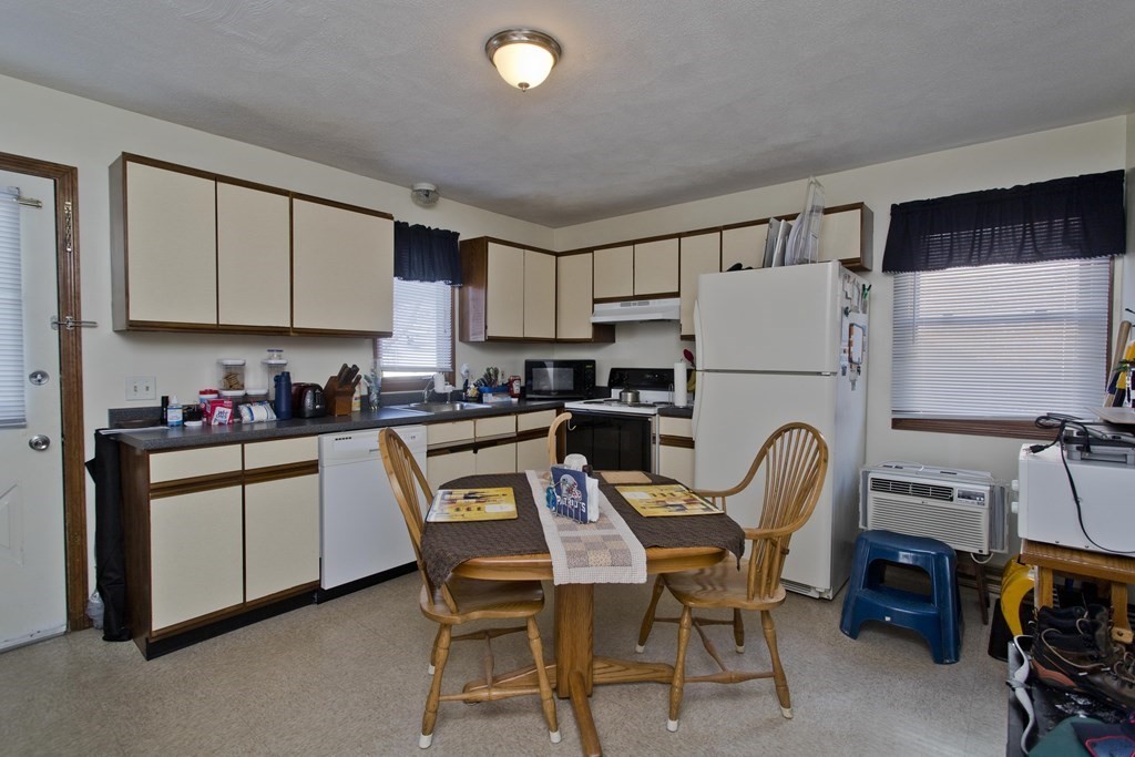 20-22 Gold Street Springfield, MA 01107 - Photo 21 of 27 a kitchen with stainless steel appliances granite countertop a refrigerator a stove a sink dishwasher and white cabinets with wooden floor