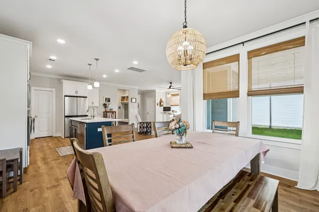 a view of a dining room and a kitchen with a table chairs