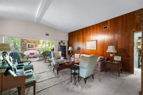a living room with furniture kitchen dining table and a large window