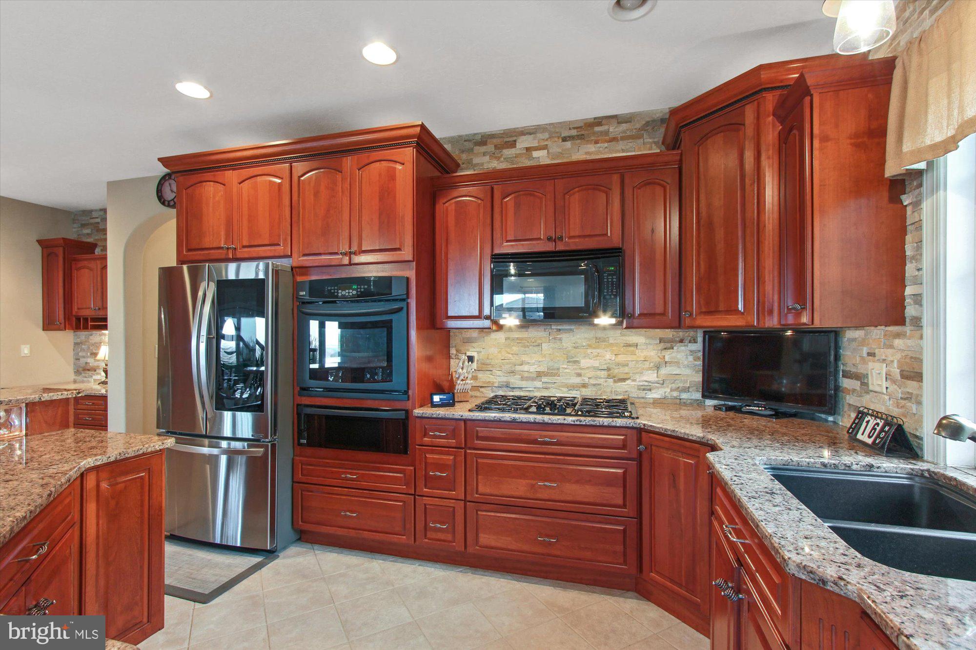 4549 Walters Hatchery Road Spring Grove, PA 17362 - Photo 11 of 64 a kitchen with granite countertop stainless steel appliances and wooden cabinets