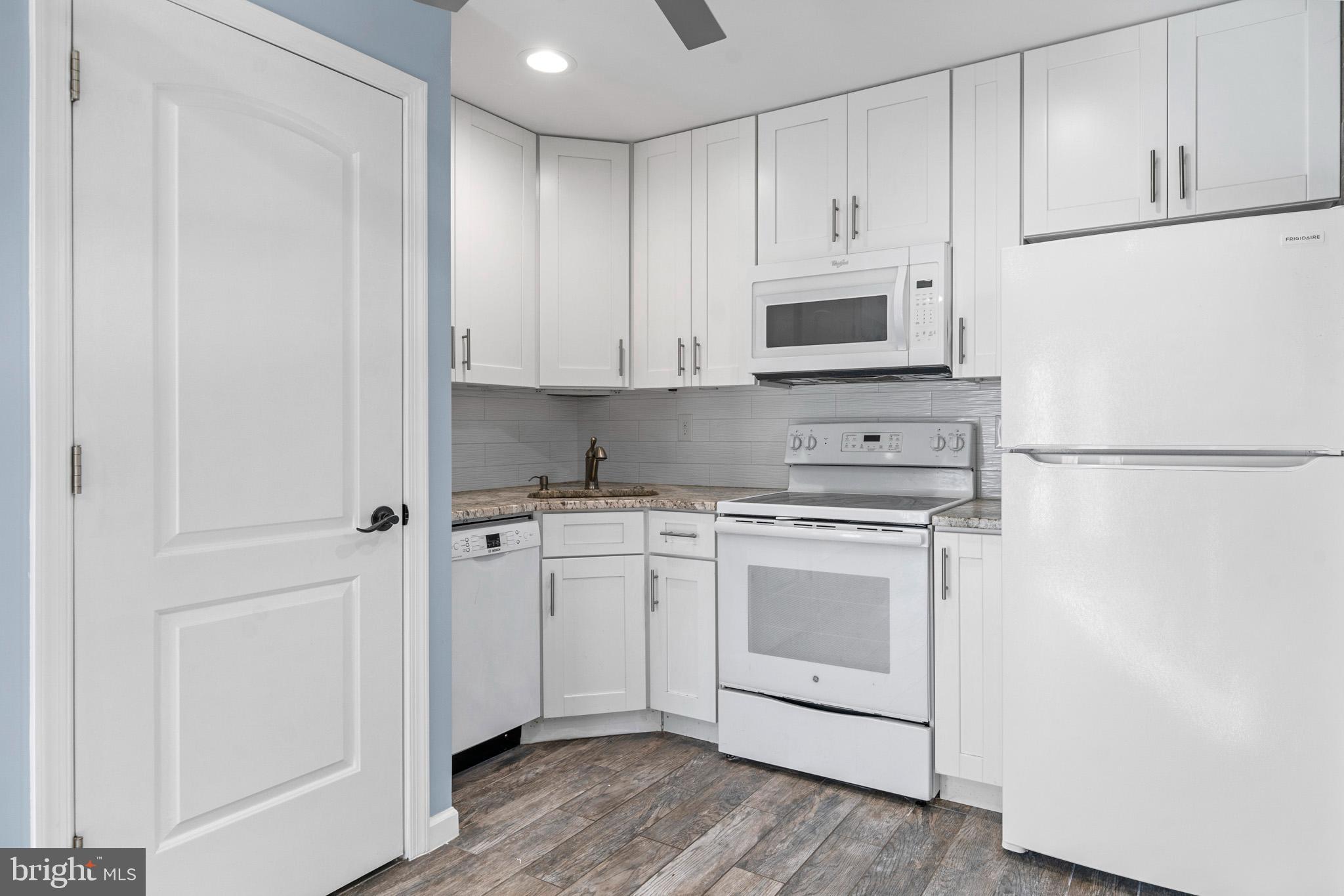 317 Biddle Road Accokeek, MD 20607 - Photo 26 of 44 a kitchen with stainless steel appliances granite countertop white cabinets and wooden floor