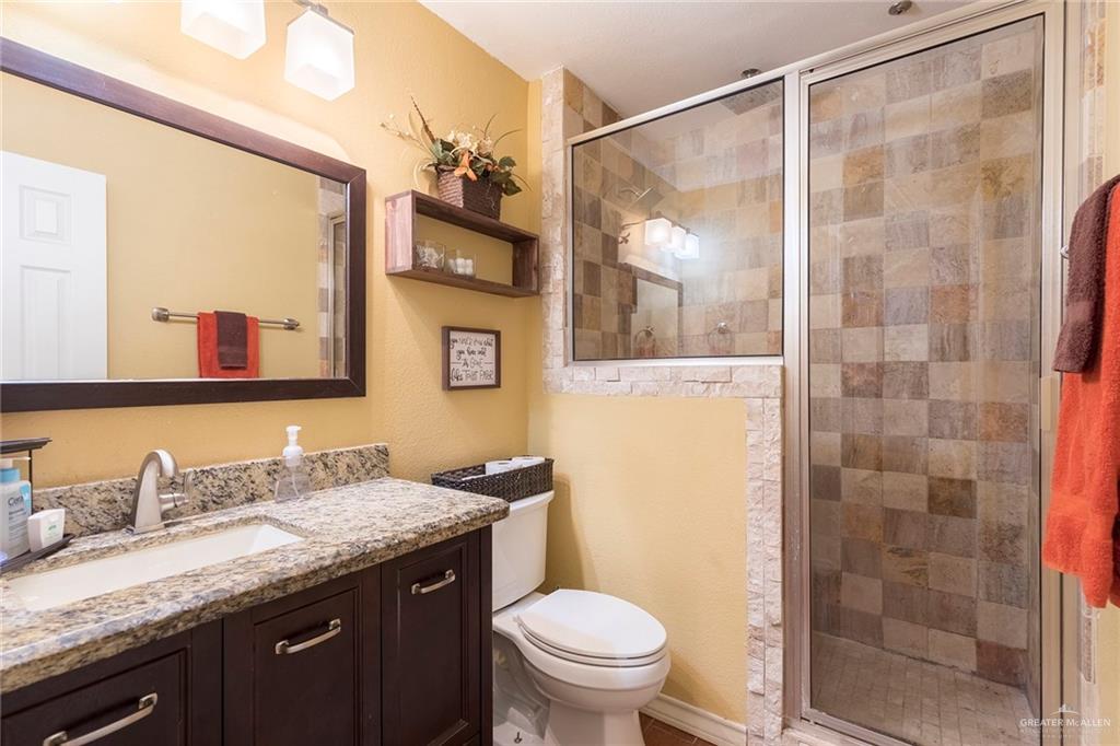 2801 Hawk Avenue McAllen, TX 78504 - Photo 12 of 19 a bathroom with a granite countertop sink toilet and shower