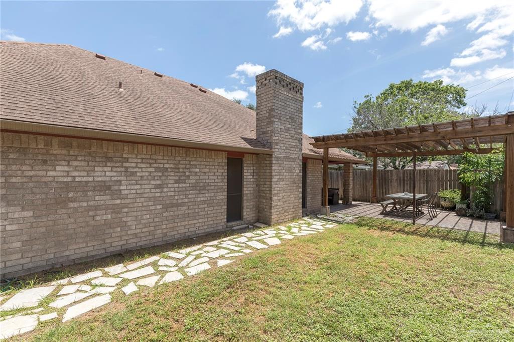 2801 Hawk Avenue McAllen, TX 78504 - Photo 15 of 19 a backyard of a house with table and chairs a barbeque with wooden fence