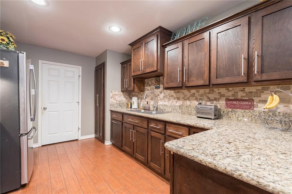2801 Hawk Avenue McAllen, TX 78504 - Photo 6 of 19 a kitchen with stainless steel appliances granite countertop wooden cabinets a sink and dishwasher